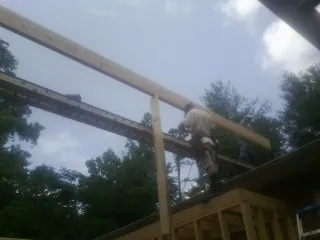 Carpenter setting a ridge beam over a new addition frame — Ice Dam Removal by Roofing Brothers in West Elizabeth