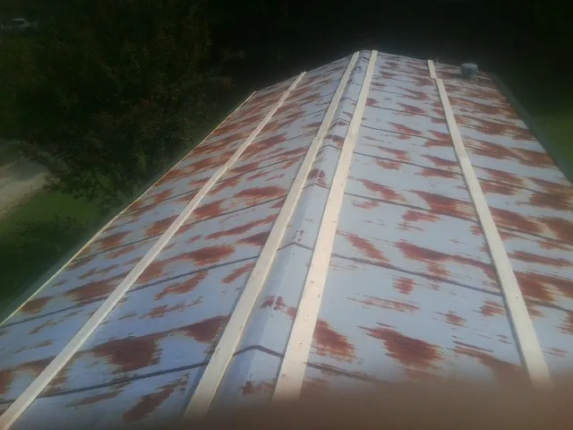 Rusted metal roof panels with new wood purlins before replacement — Storm Damage Roof Repair in West Elizabeth by Roofing Brothers