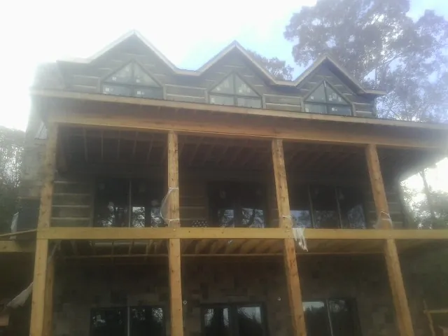 Dormers and porch framing on a large log home under construction — Roof Coating work by our crew in West Elizabeth
