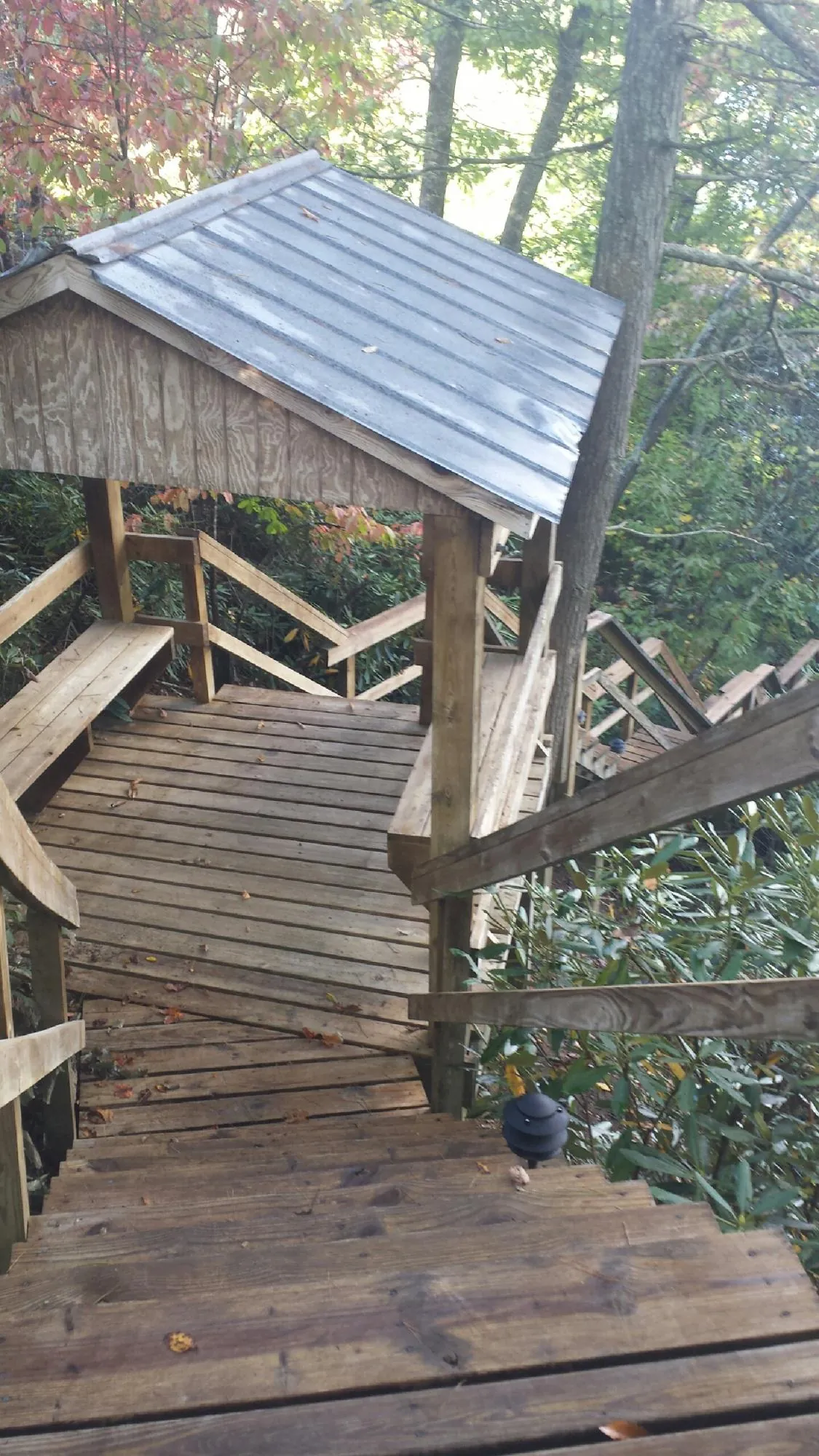 Metal roofed shelter over wooden steps on a wooded walkway — Skylight Repair & Installation work by our crew in West Elizabeth